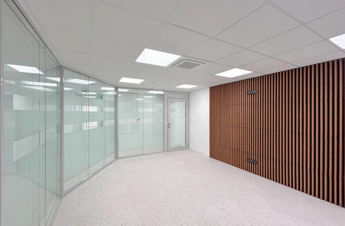 Plateau de bureaux livré avec cloisons vitrées, faux plafond acoustique et claustra bois