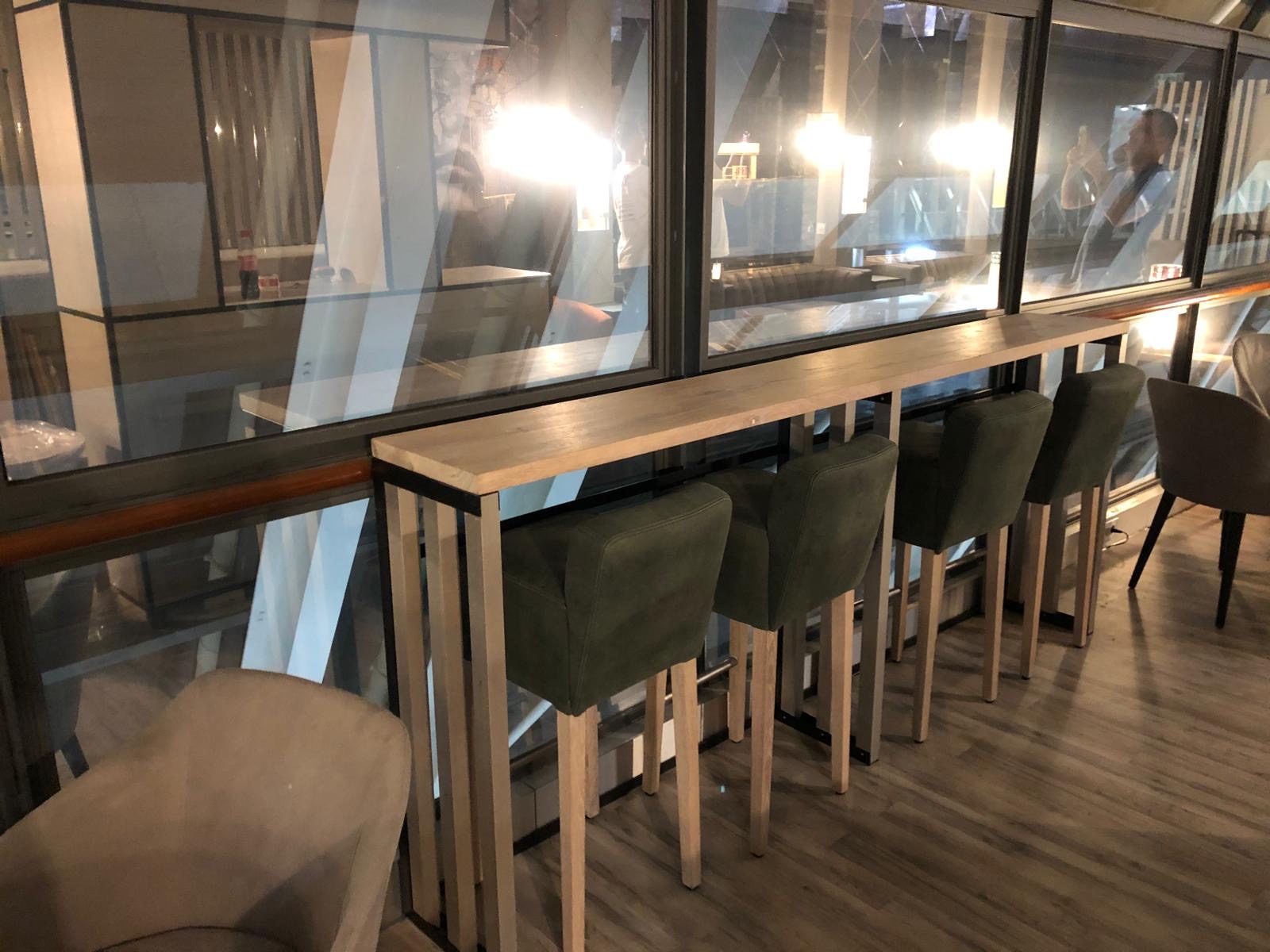 Mange-debout et tabourets le long de la verrière du lounge