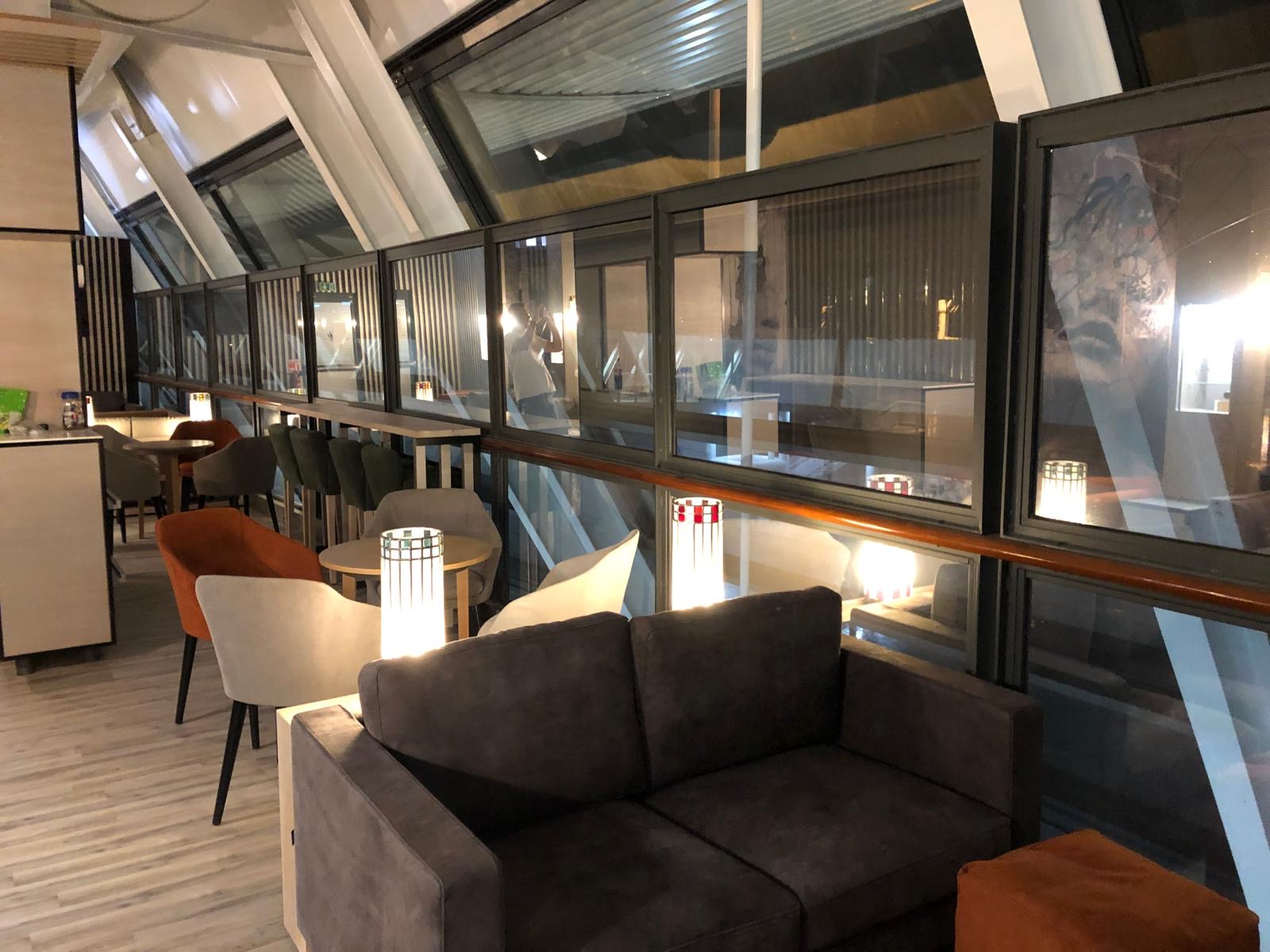 Espace détente panoramique du lounge le long de la verrière inclinée