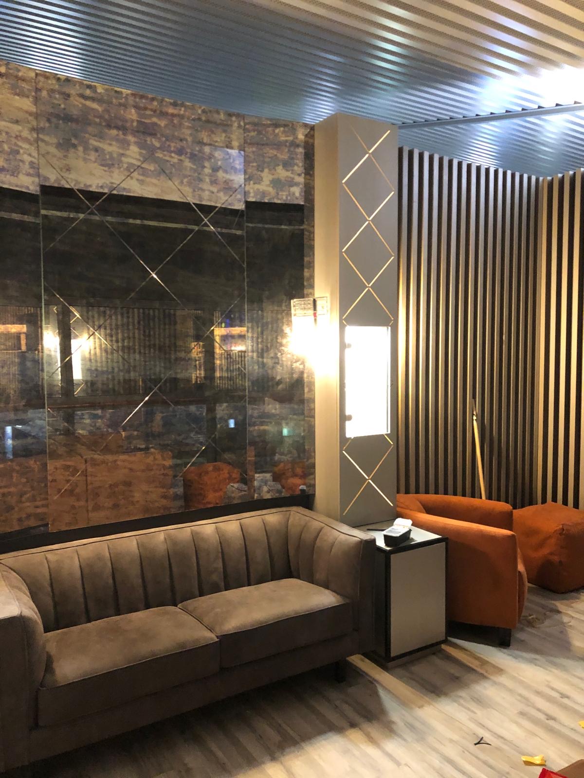 Détail de l'aménagement du bar-lounge — habillage bois, miroirs et éclairage d'ambiance