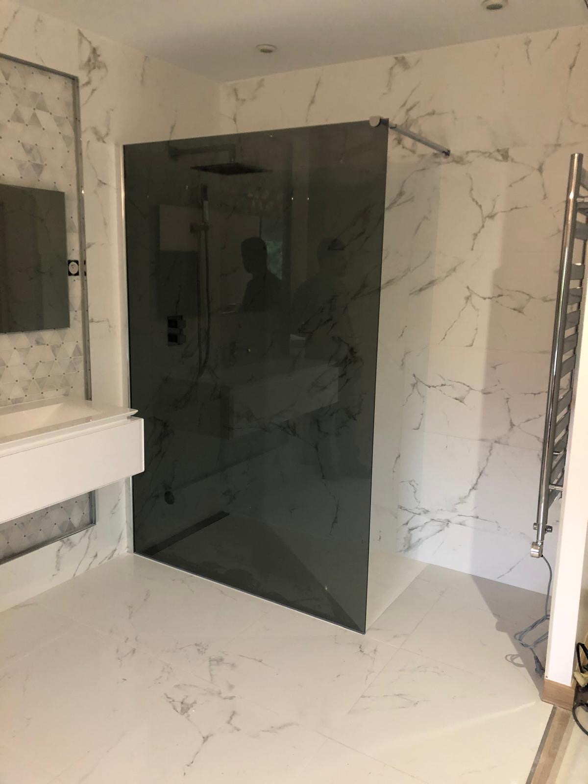Douche à l'italienne avec paroi fixe en verre fumé et sèche-serviettes chromé